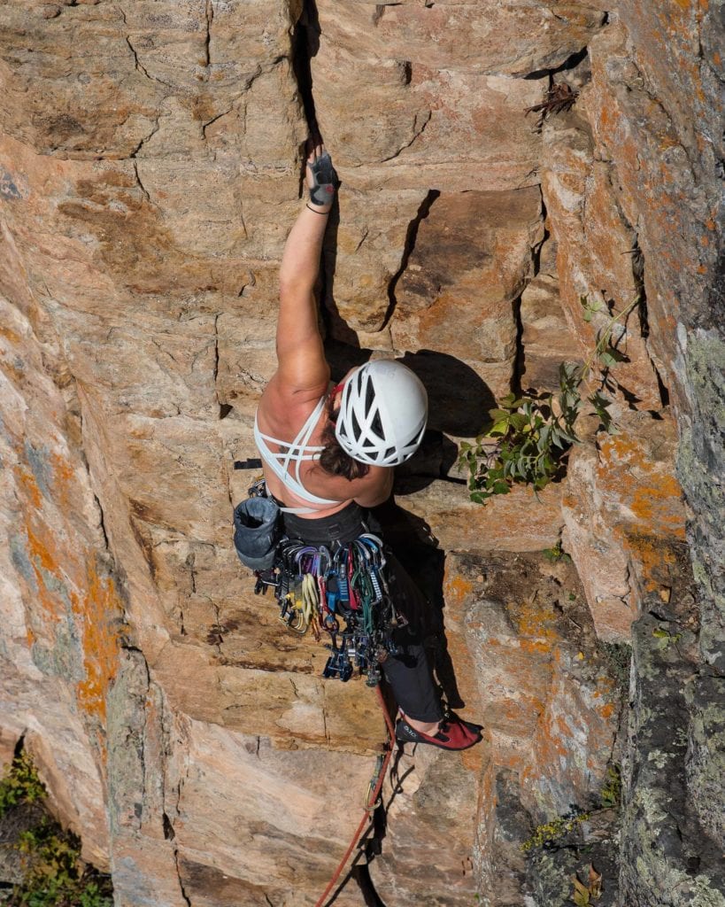 Rock climber uses crack climbing gloves to ascend a cliff