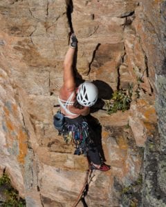 Rock climber using crack climbing gloves to ascend a cliff