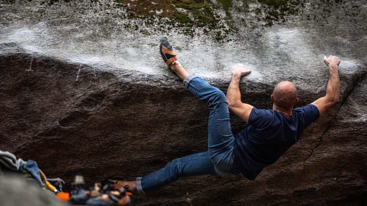 Male boulder traverses rock in La Sportiva Pythons