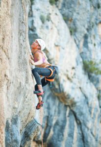 Female climber climbs Greece limestone in Petzl Hirundos Harness
