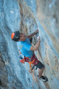 Steve McClure climbs Greek limestone during Petzl RocTrip
